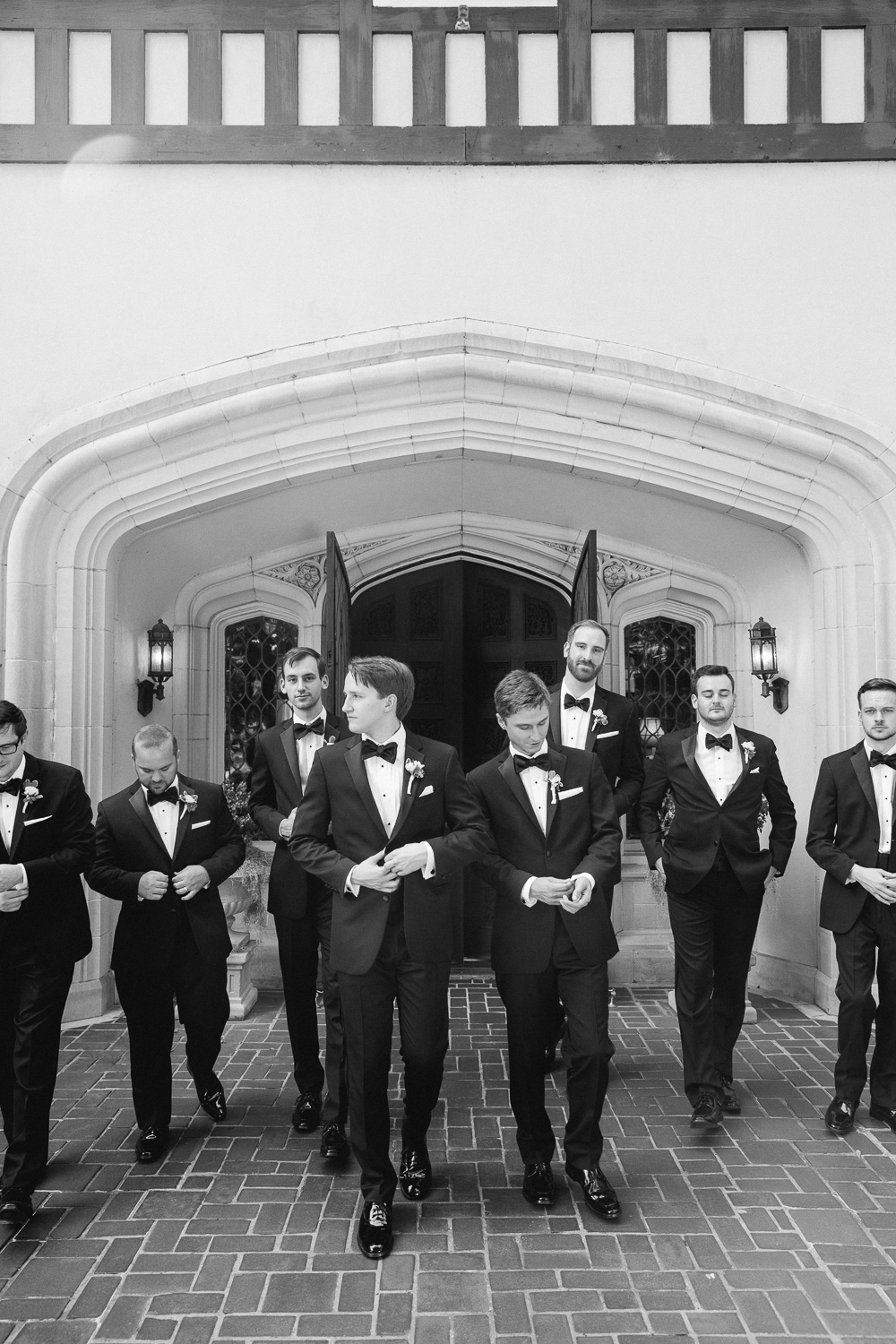 groom and groomsmen walking in tuxes in front of Callanwolde Fine Arts Center