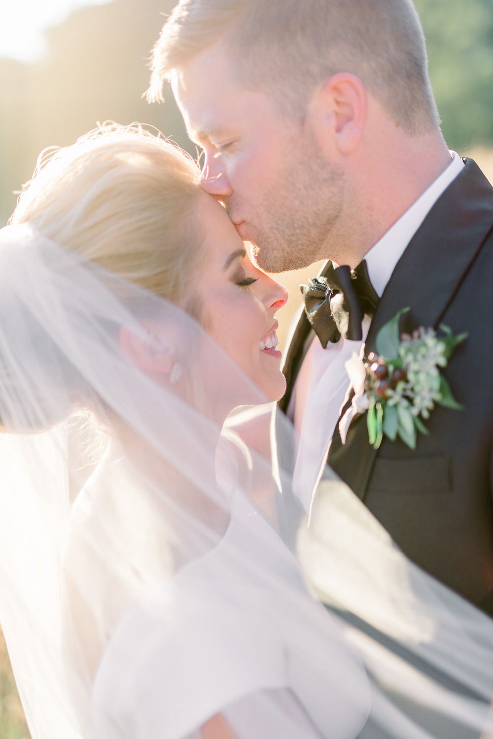 groom kissing bride's forehead 