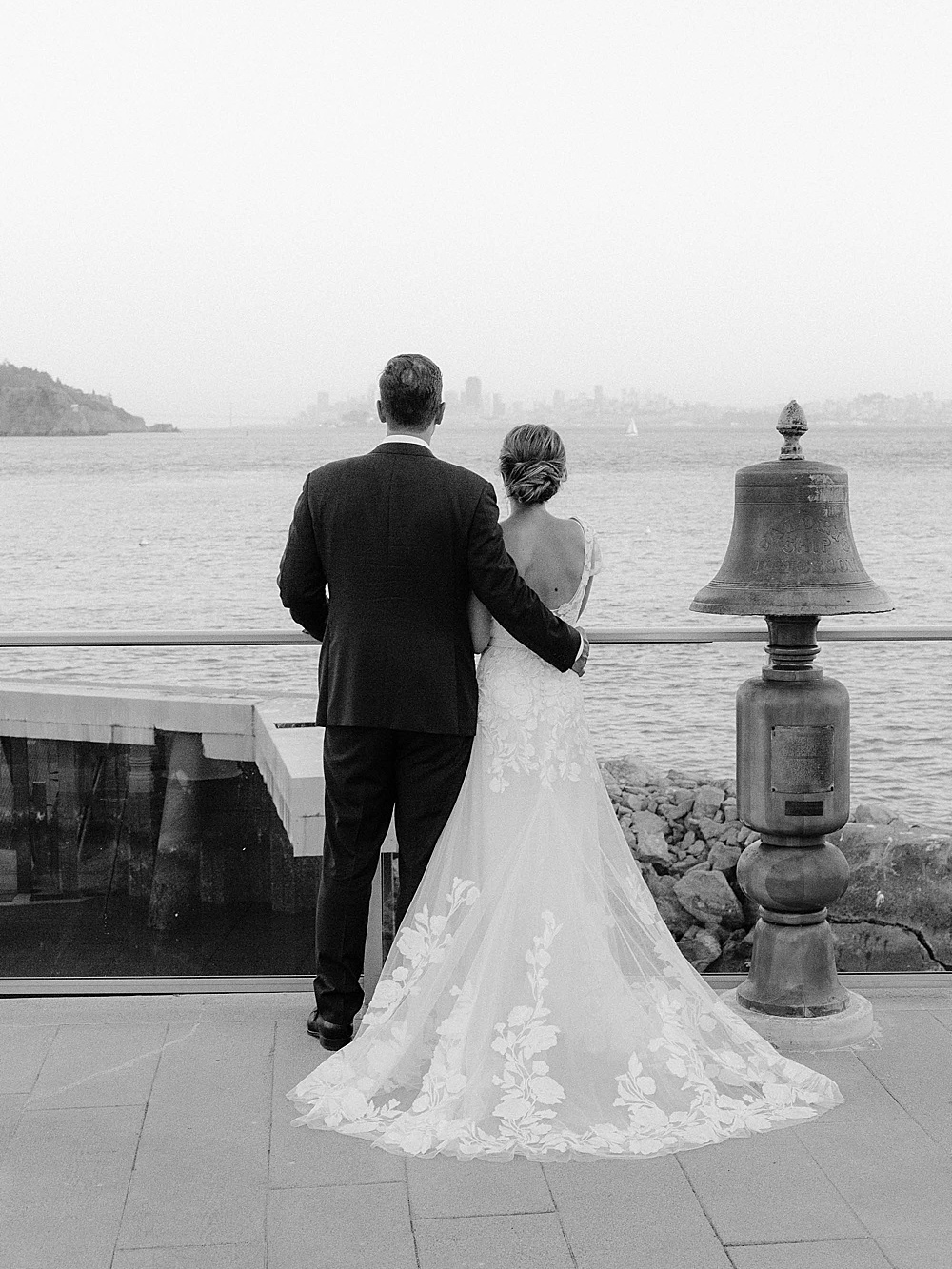 bride and groom looking at the san francisco skyline from the corinthian yacht club