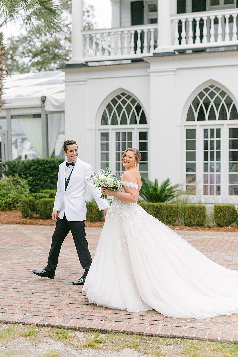 bride and groom walking in front of Lowndes Grove