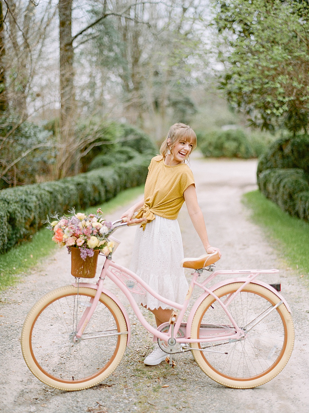 girl smiling with a pink bike with flowers in the basket at Meadowlark 1939