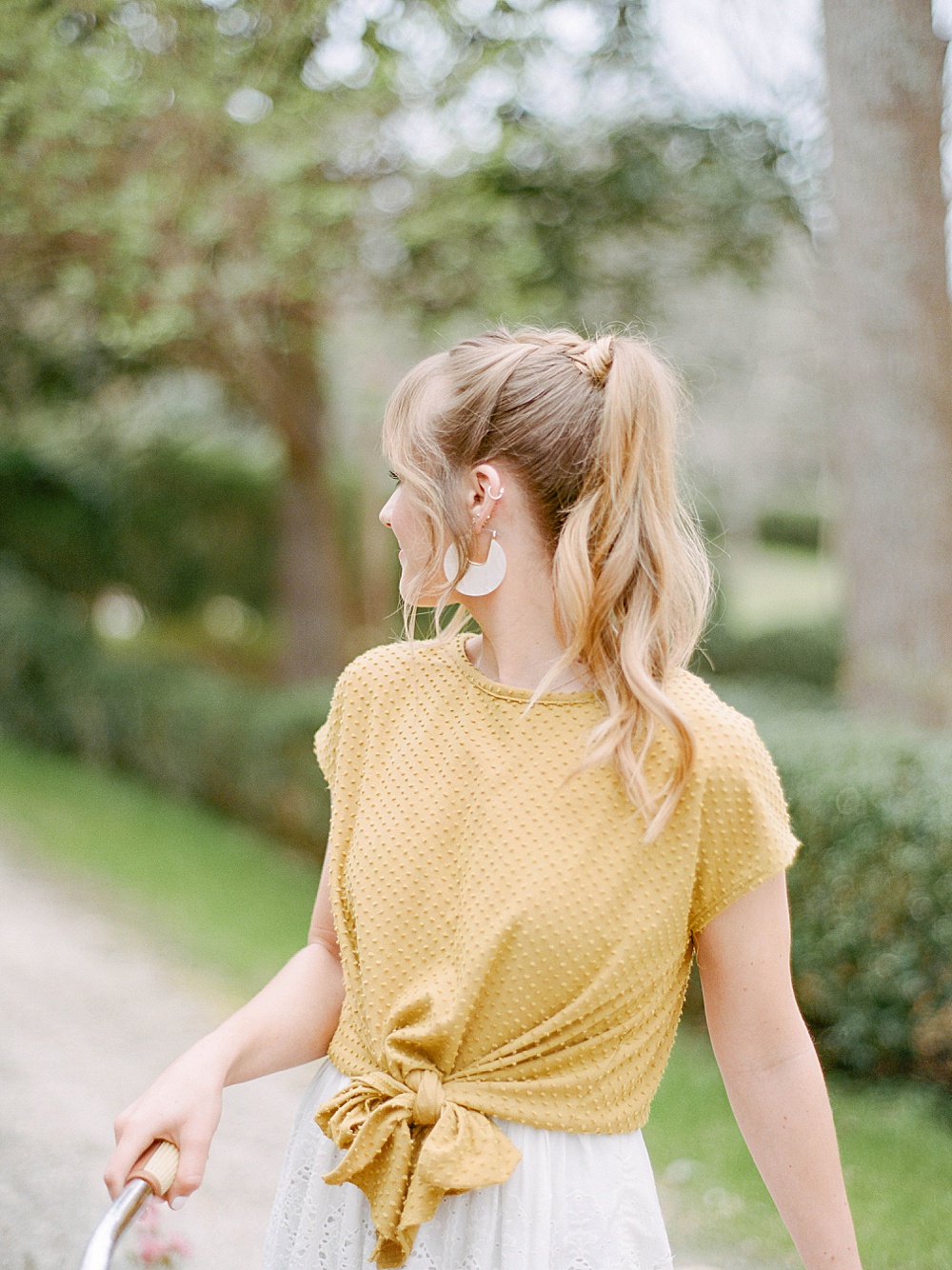 girl in yellow wearing a pony tail for her engagement portraits