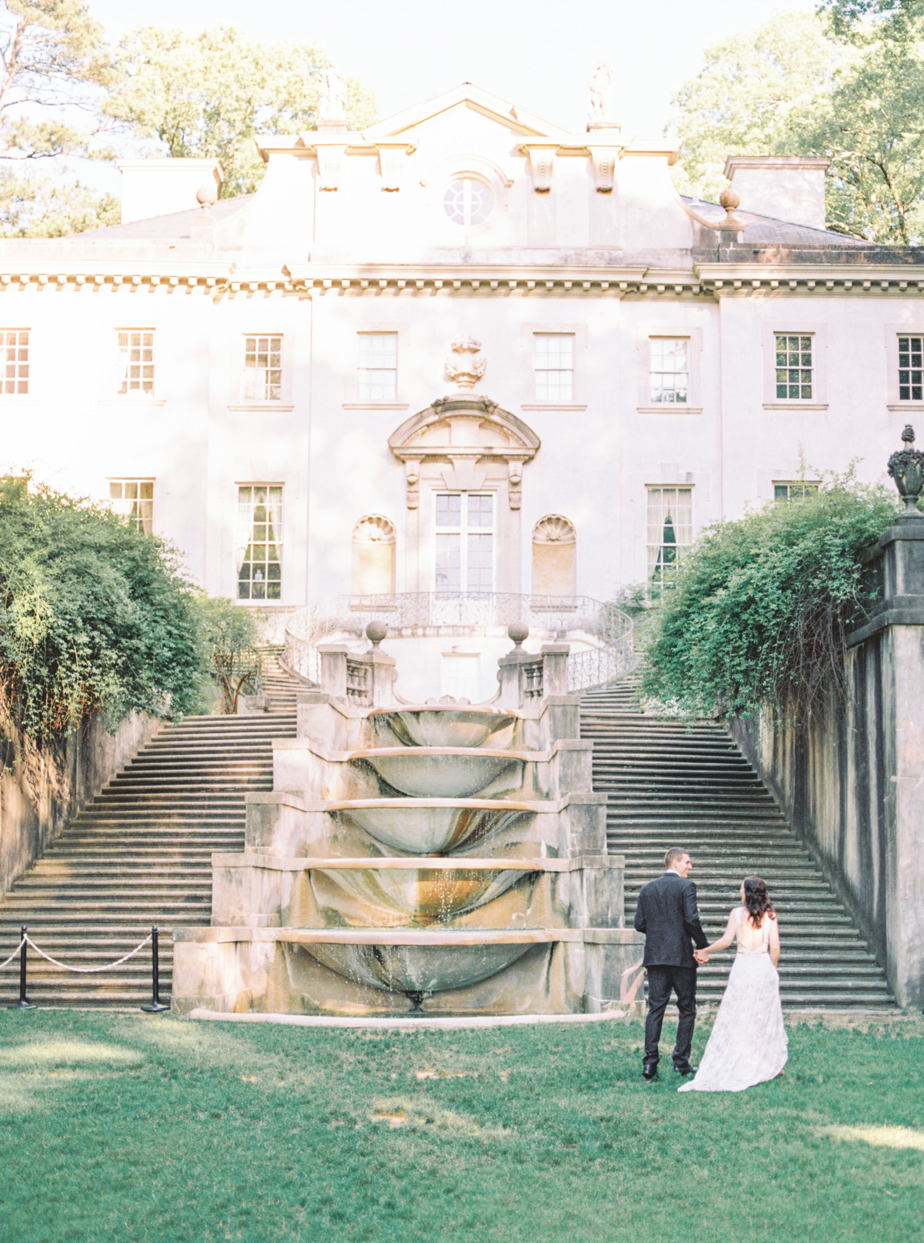 Wedding couple walking up the back steps of the Swan House in Atlanta that was featured in the Hunger Games