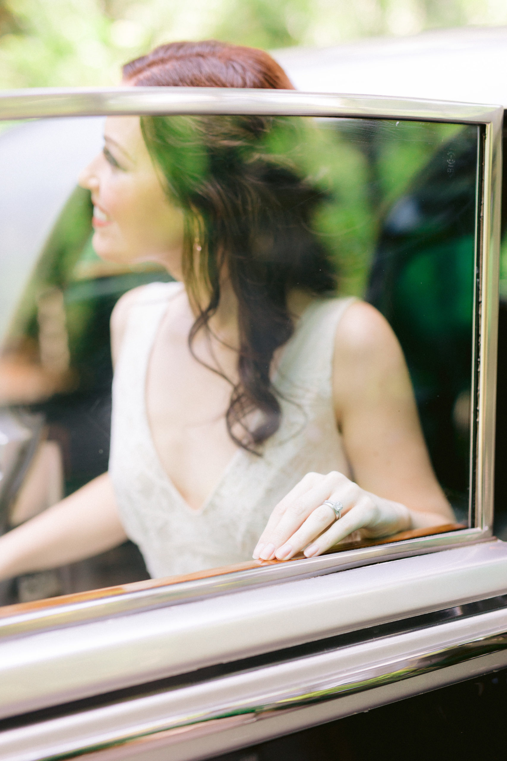 Bride's hand on the window of an old car