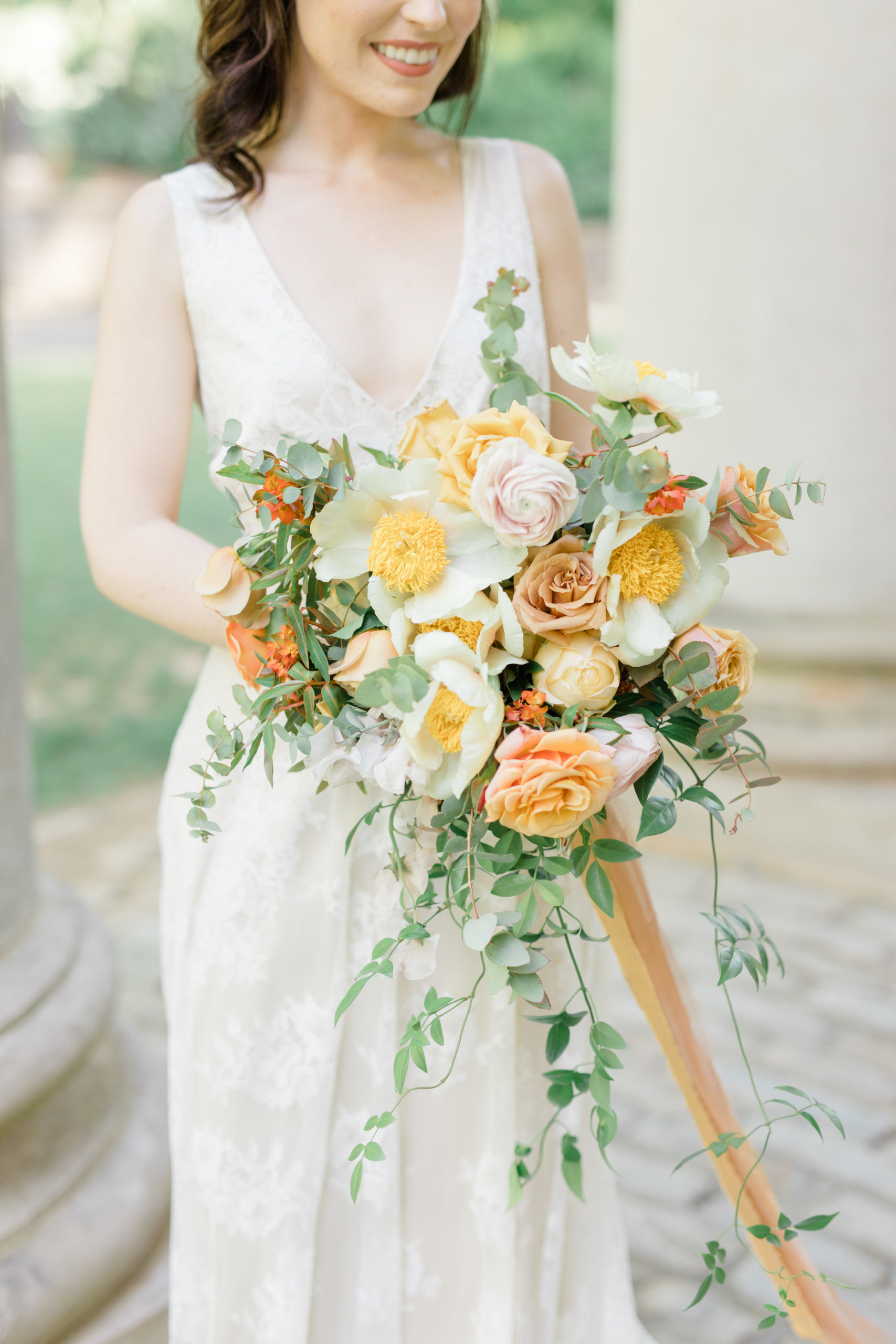 Yellow and orange wedding bouquet with peonies, poppies and garden roses.