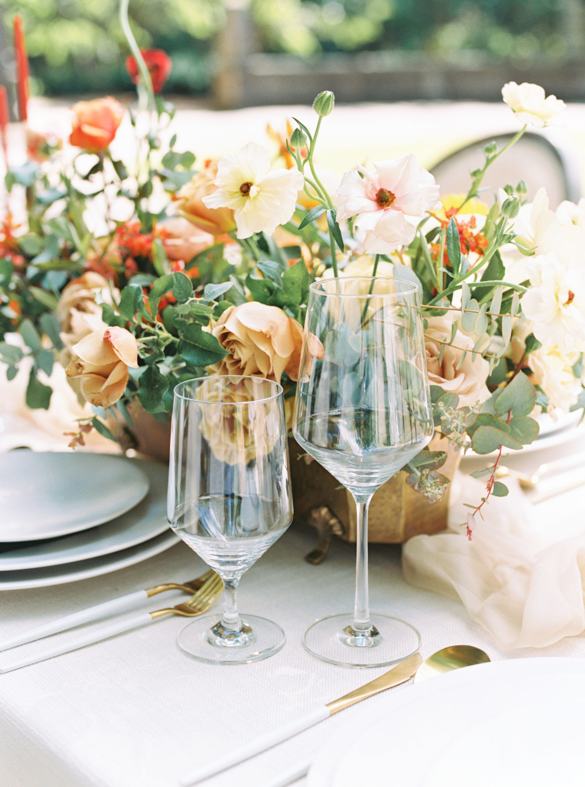 Elegant wine glasses with a wild floral arrangement on a table for a wedding