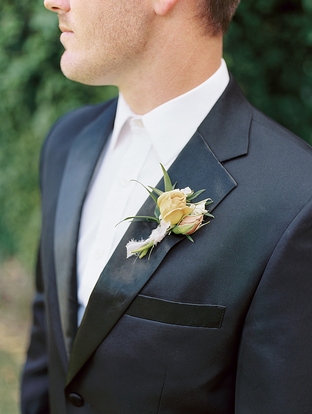 gold and blush boutonniere on navy suit
