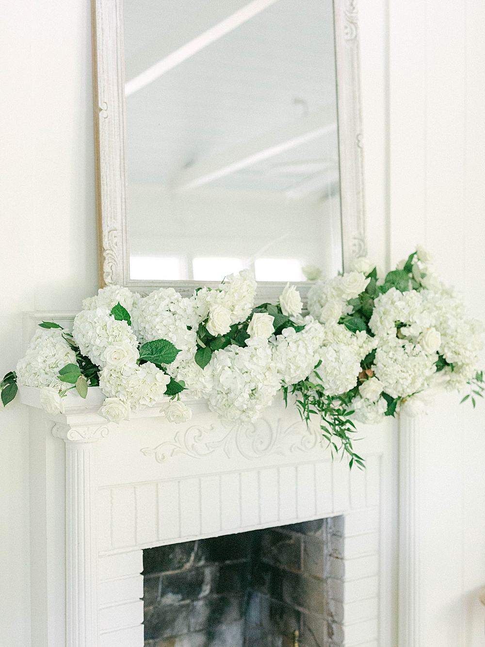 White floral arrangement on fireplace mantel