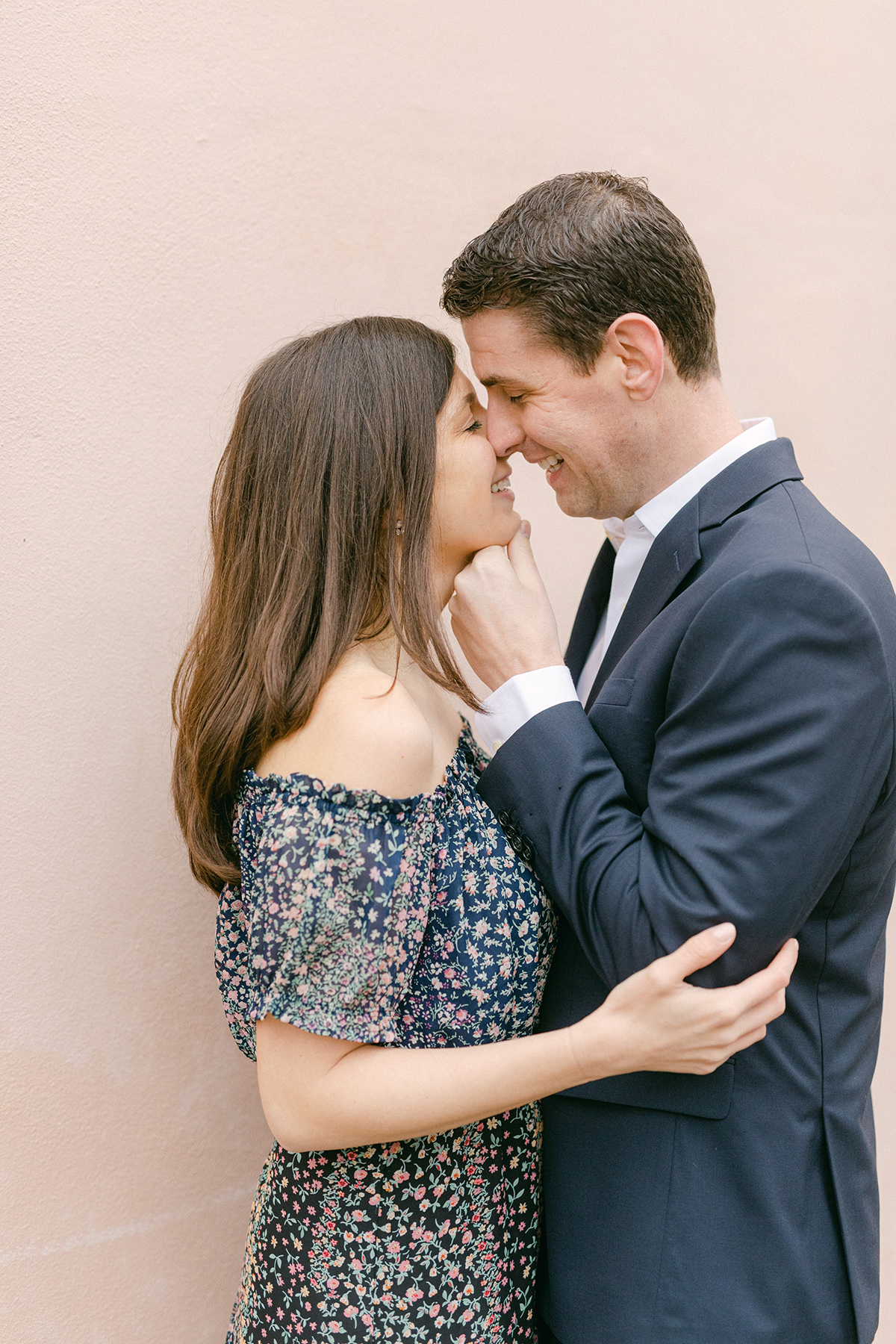 Engagement session in downtown Charleston against a pink wall