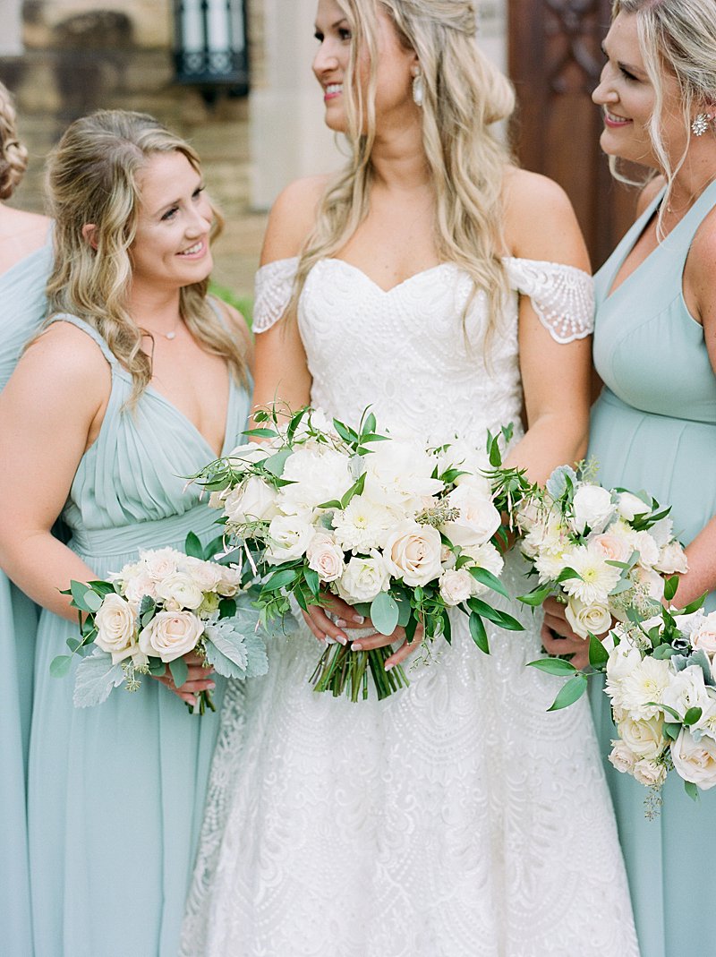 Teal bridesmaids dresses with bouquets made from blush roses and eucalyptus