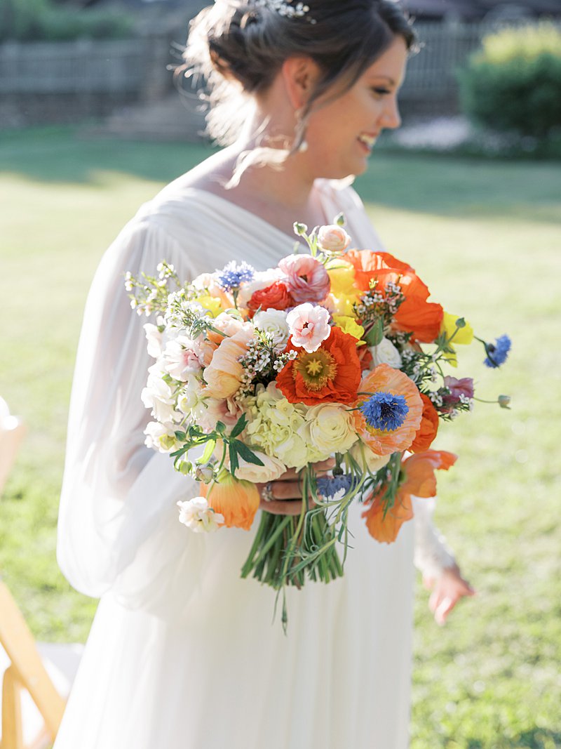 Warm and colorful wedding bouquet with red, orange and yellow flowers for a summer wedding