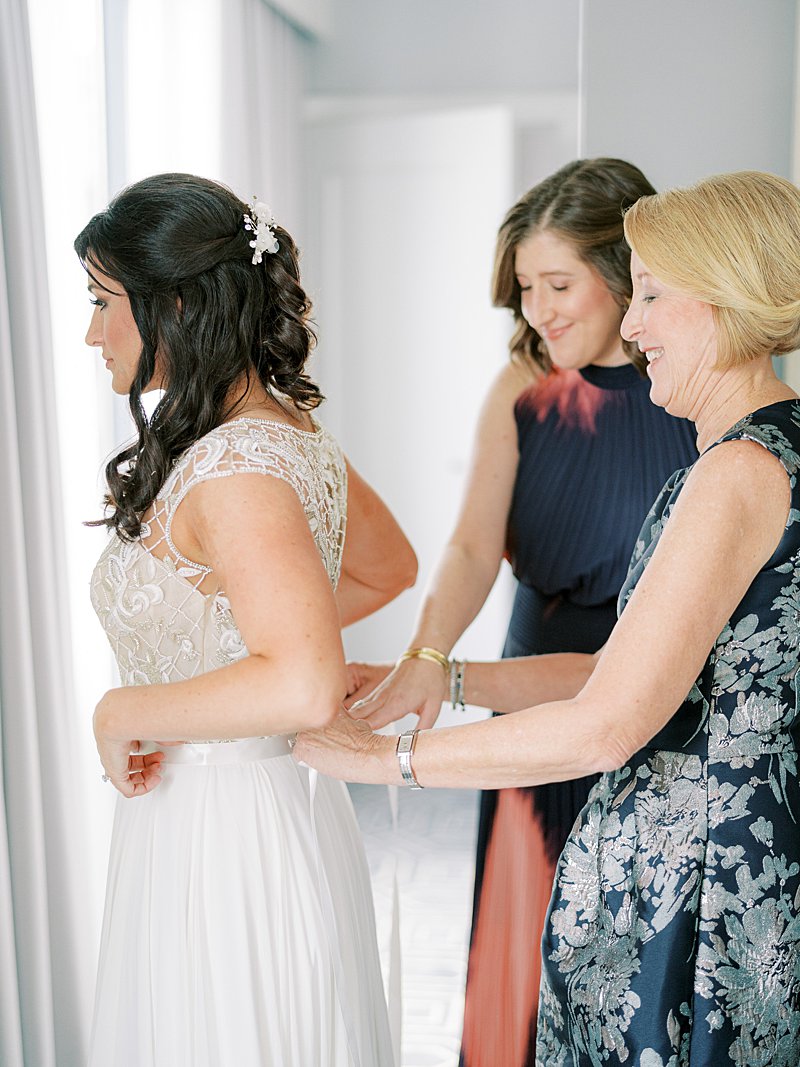 Mother tying bride's dress