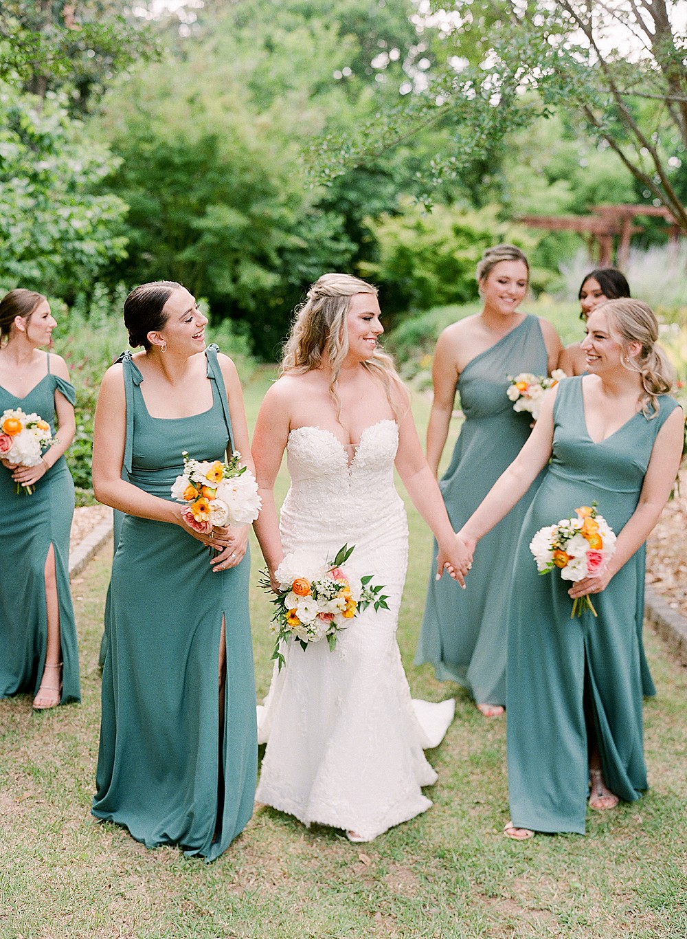 Bridesmaids walking with bride wearing jade green wedding dresses