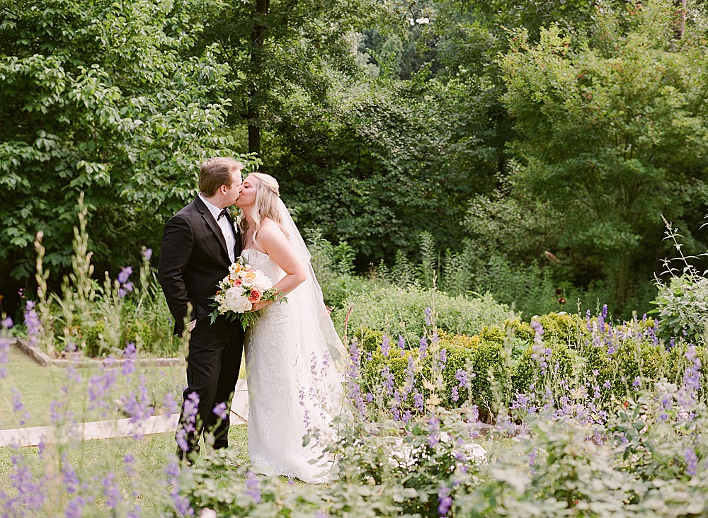 Bride and groom kissing in Callanwolde Estate's gardens