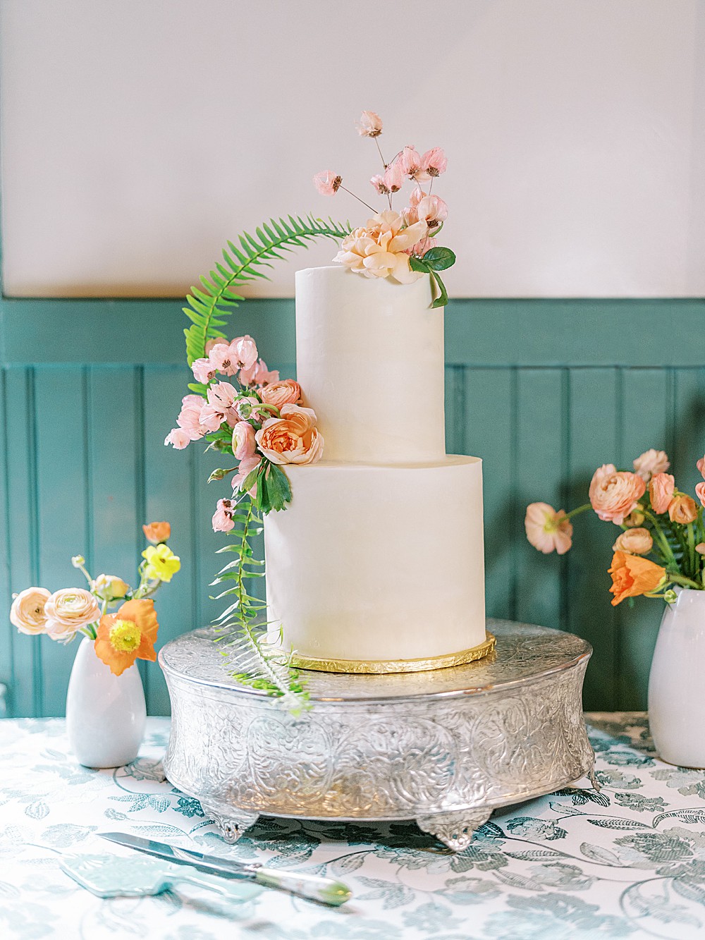 Simple white buttercream wedding cake with Spring flowers by Sugar and Slate