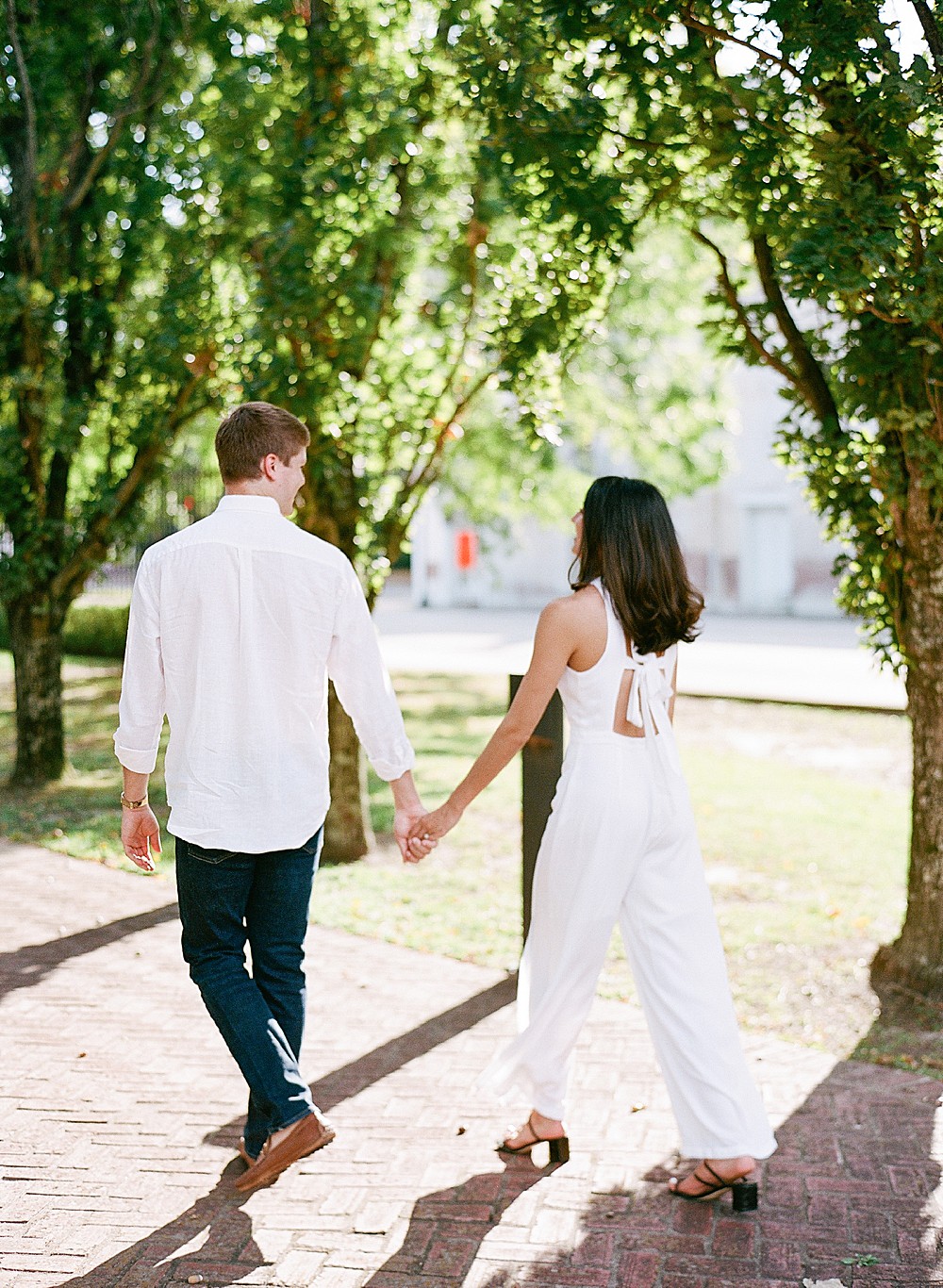 Bride wearing a white jumpsuit with bow in the back for engagement session