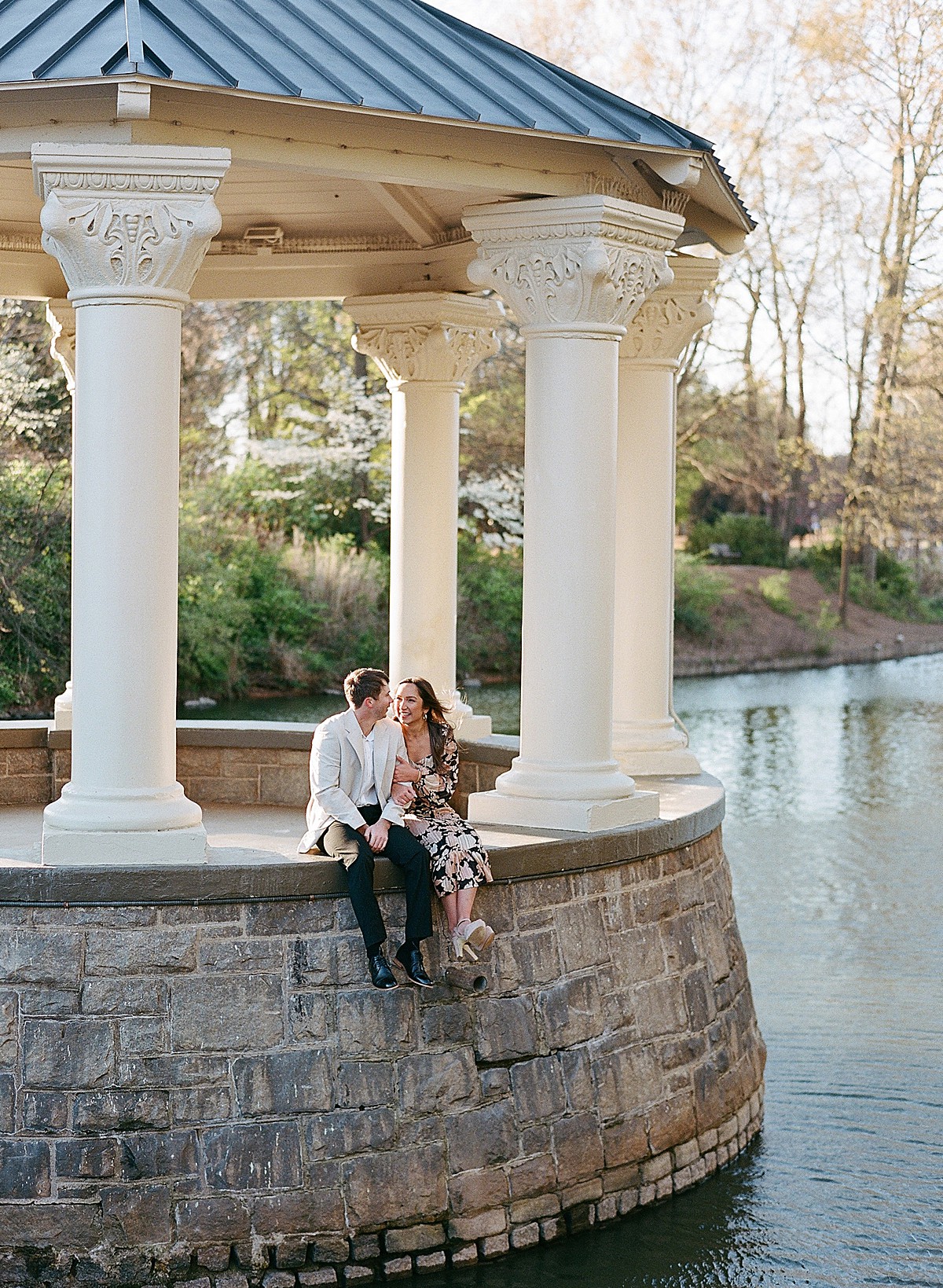 Man and a woman sitting side by side on the gazebo over the lake at Piedmont Park in Atlanta, Georgia