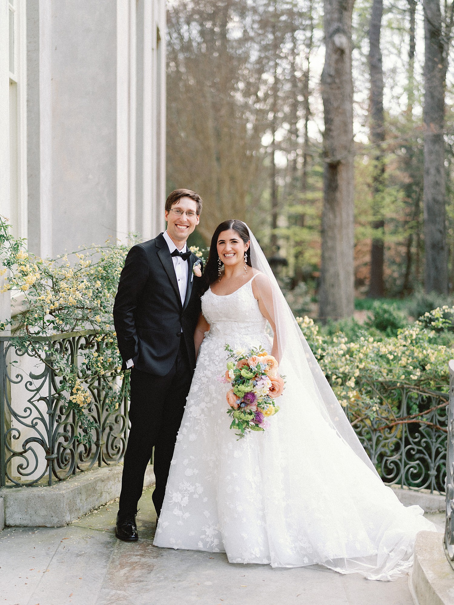 A smiling portrait of the bride and groom on the back staircase of the Swan House