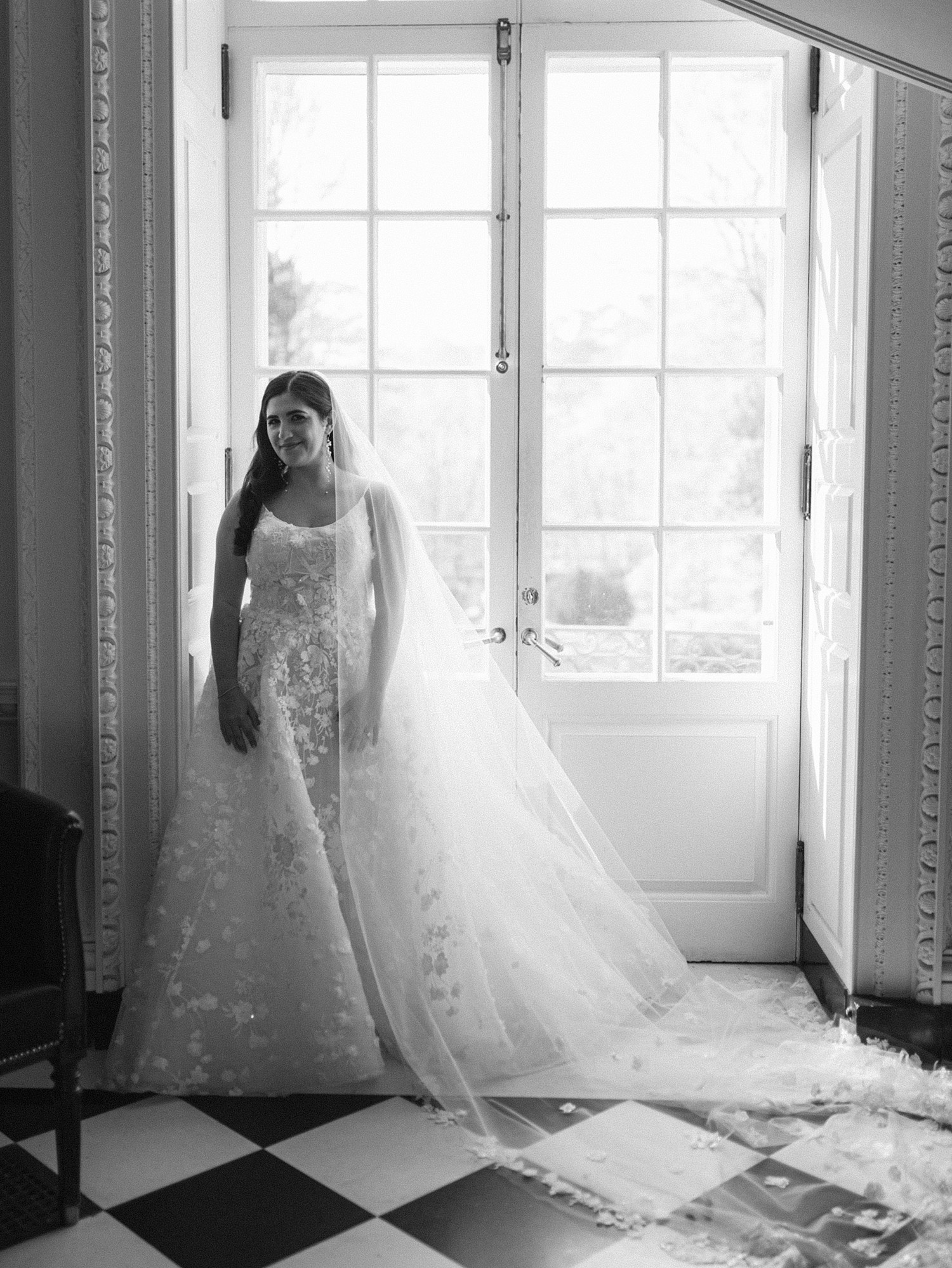 A black and white bridal portrait at the back windows from the inside of the Swan House