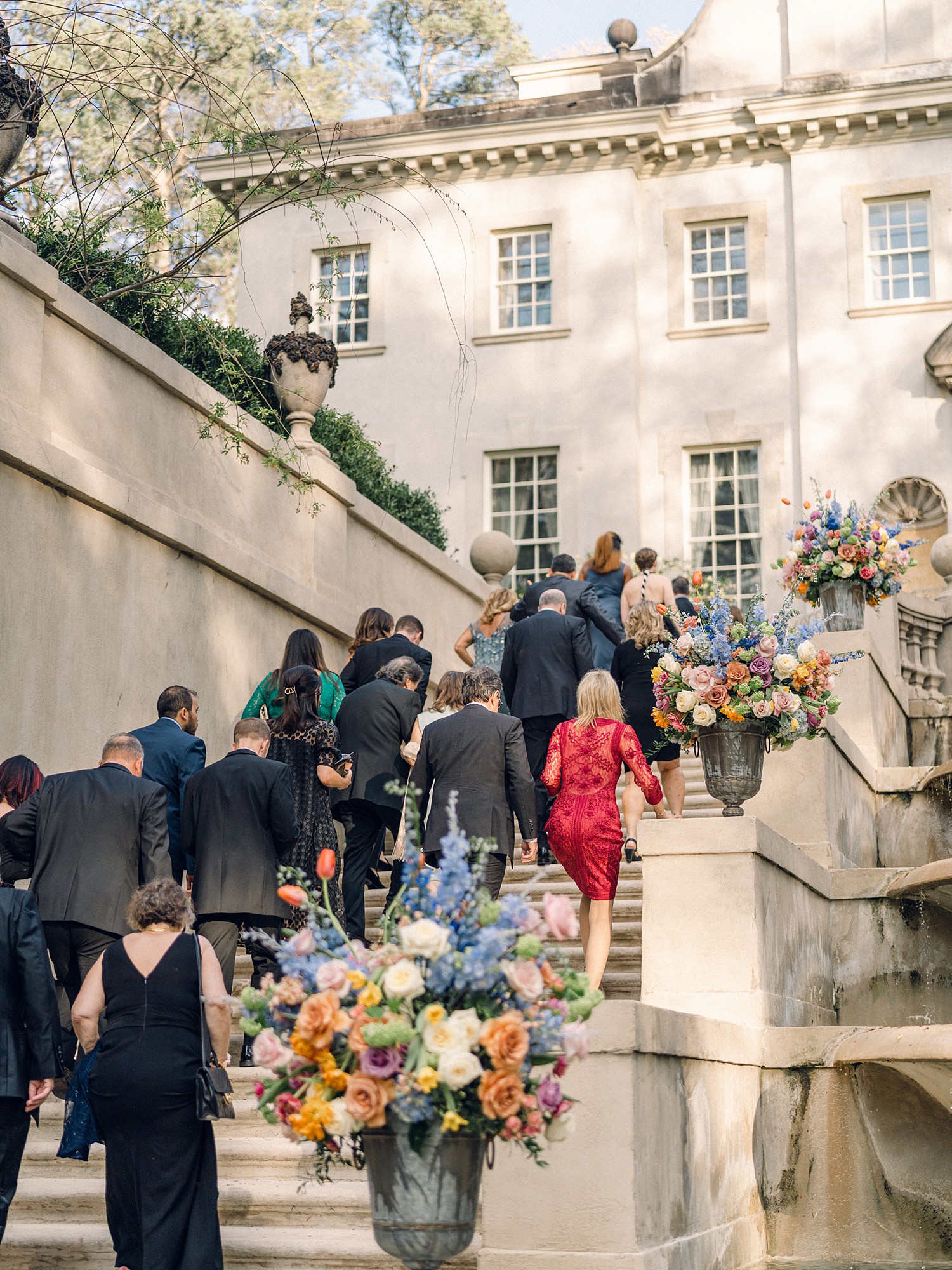 Guests walking up the Swan House steps to cocktail hour after the ceremony