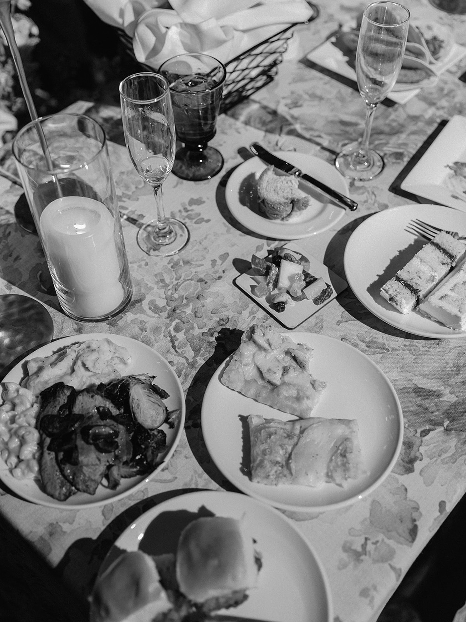 A black and white photo of leftover food on the sweetheart table of a wedding