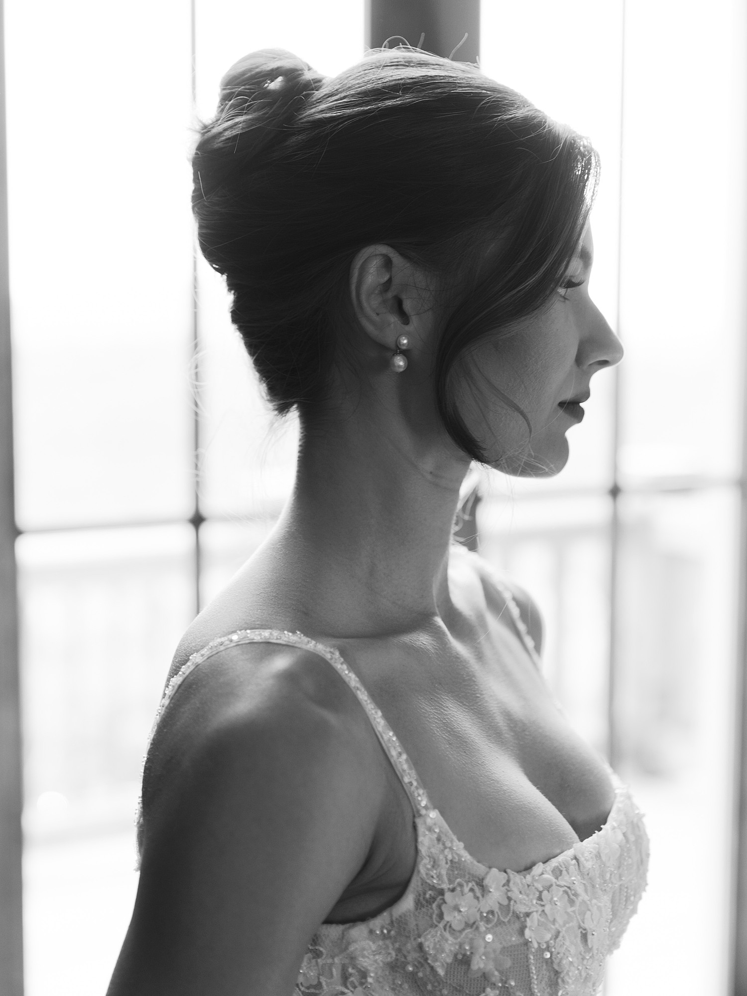 A black and white image of a bride. It's a close up that shows her earring and decolletage