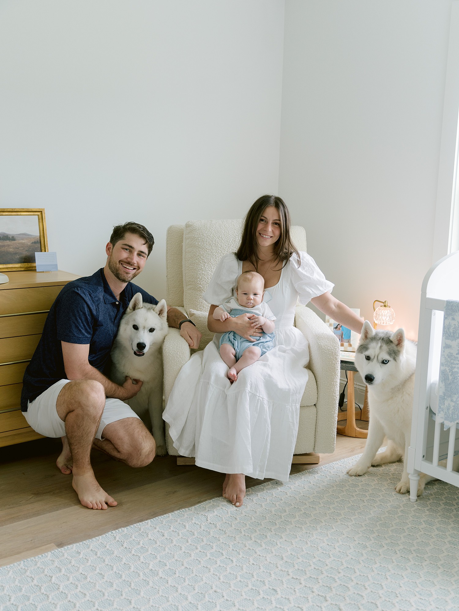 A portrait of a young family in their son's nursery complete with their two huskies captured by Senoia family photographer, Laura Watson