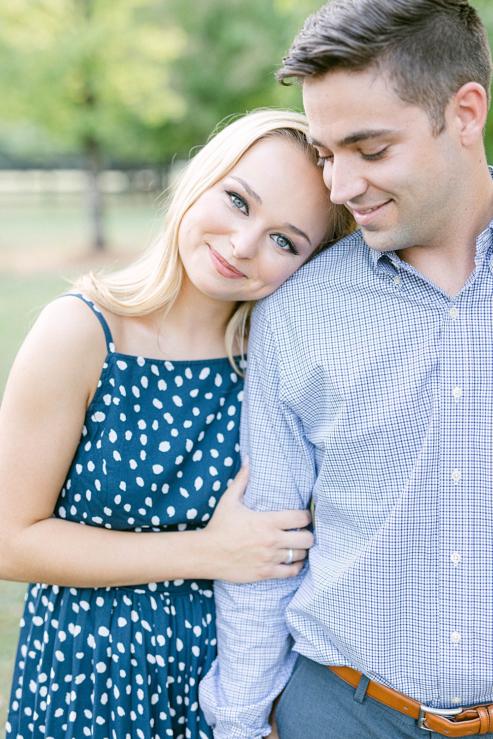 girl resting her head on her fiancé's shoulder and smiling at the camera at The Stables at Foxhall Resort