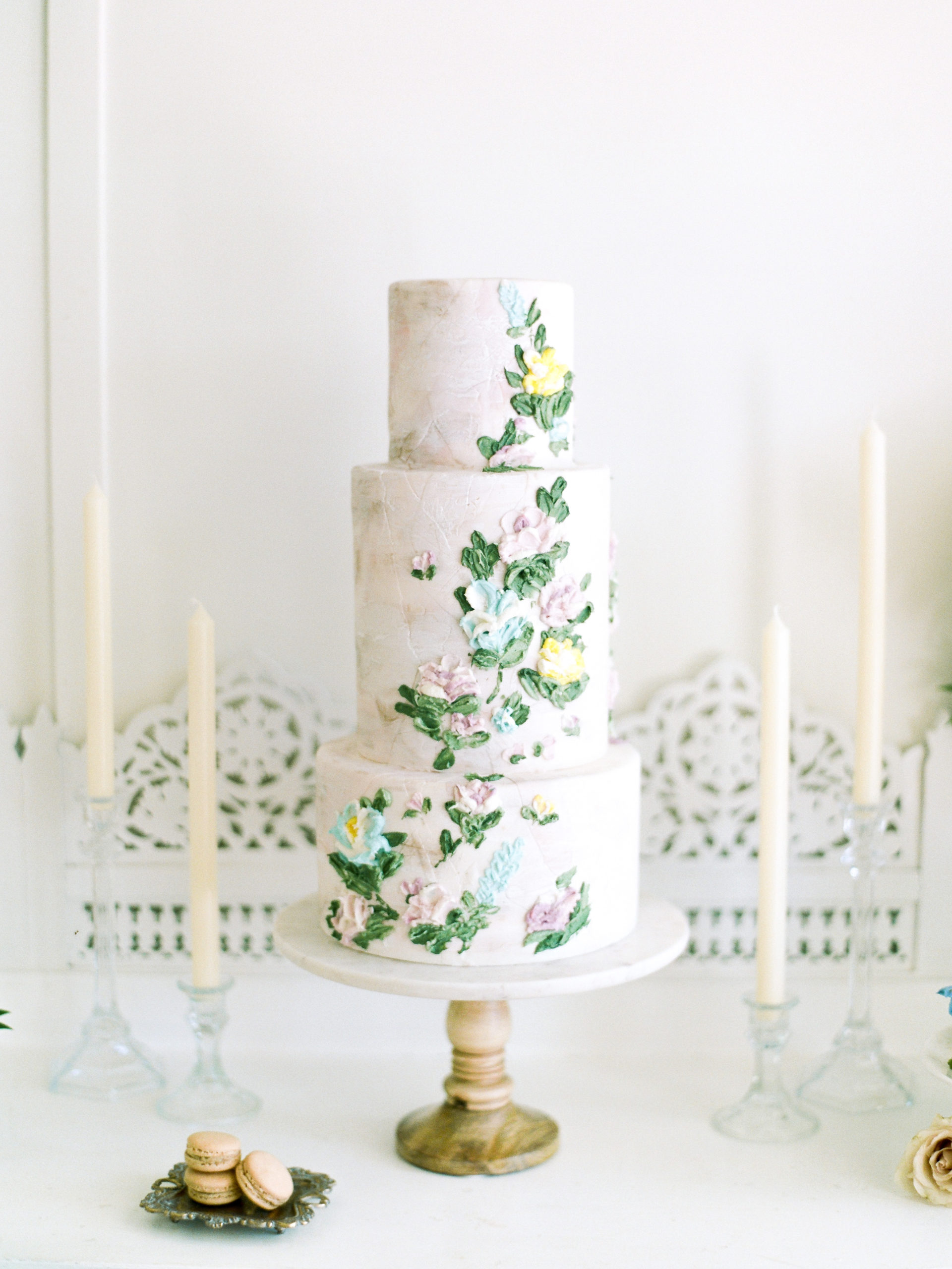 Three tiered wedding cake with greenery and white