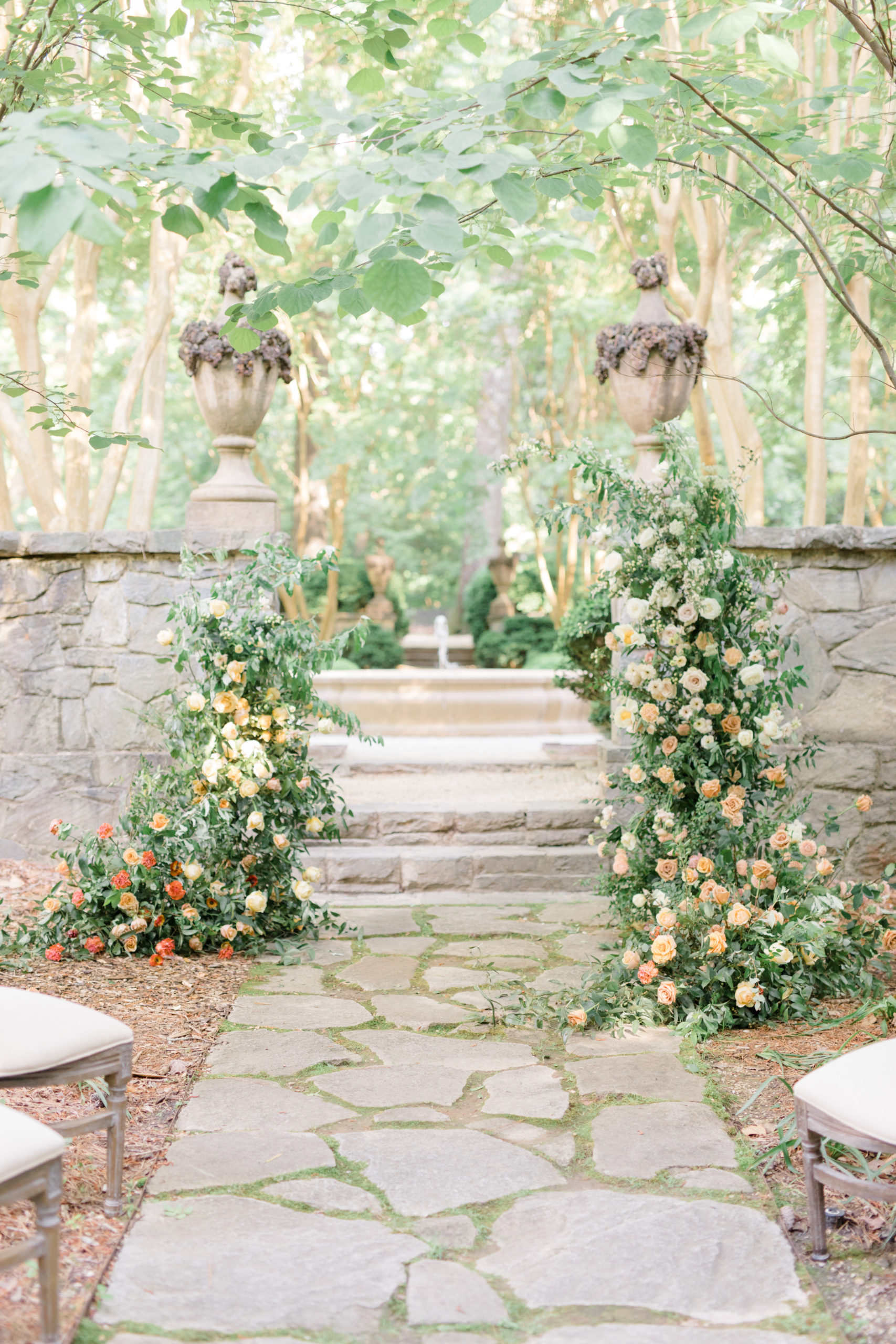 Ceremony floral installation with greenery, yellows and oranges