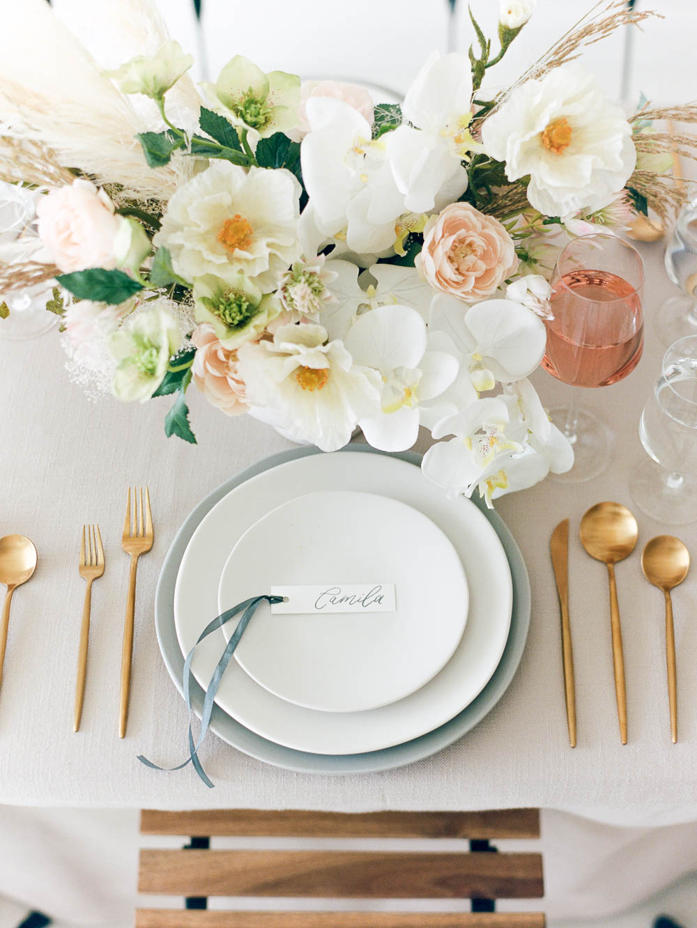 Pink, gold and blue table setting with white orchid floral centerpiece by Taylor Dawn
