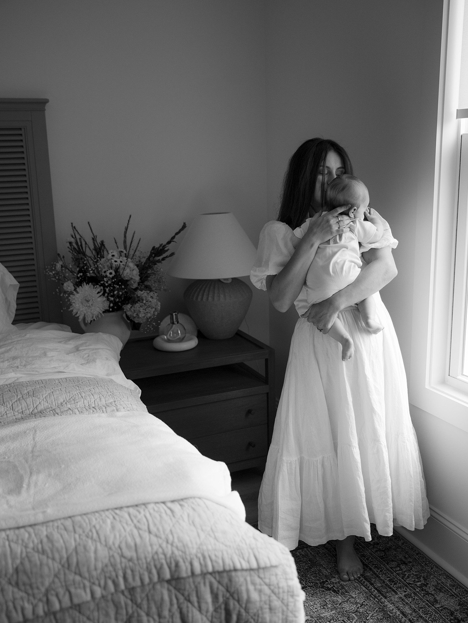 A new mom holding her son close and swaying with him in her arms