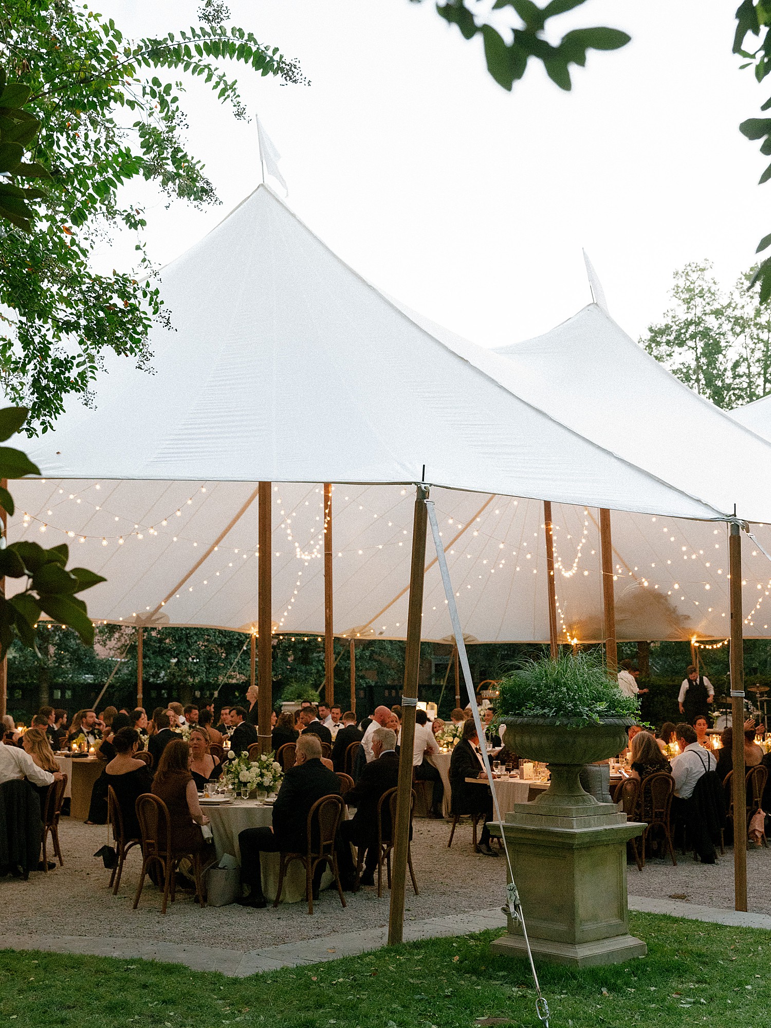 A full view of a tented reception in the backyard of the Gibbes Museum for a wedding. The light in the image is low and the warm candlelight is setting the scene beautifully.