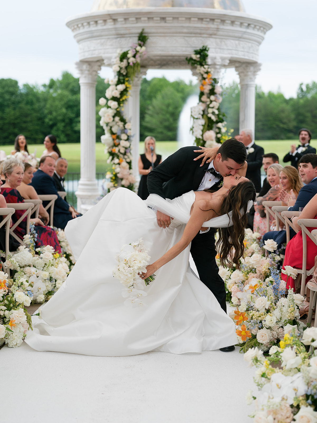A bride and groom share a kiss while going down the aisle after saying "I do" at the Conservatory at Blackberry Ridge